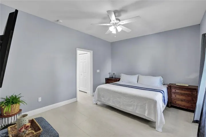Tiled bedroom featuring ceiling fan