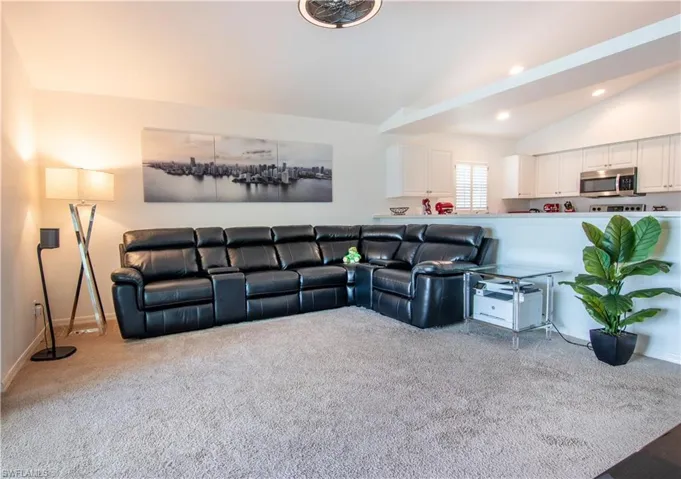Carpeted living room with lofted ceiling