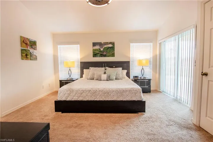 Carpeted bedroom featuring multiple windows