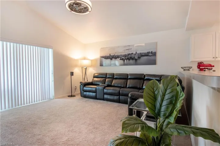 Carpeted living room featuring vaulted ceiling