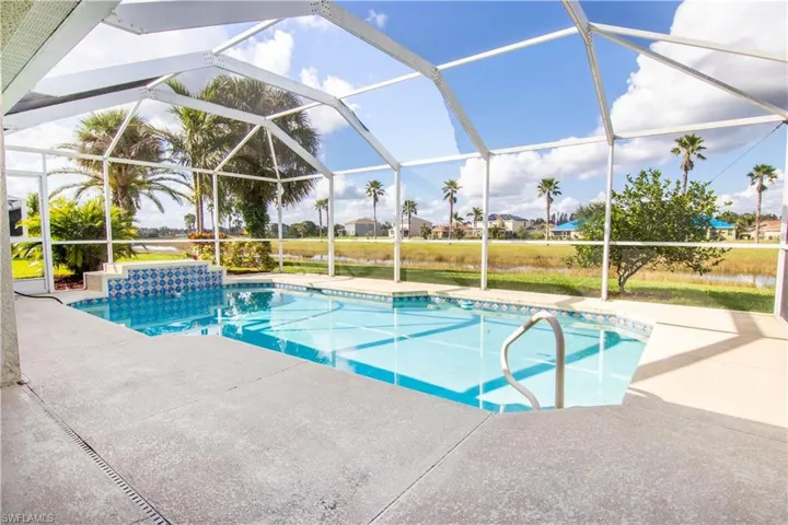 View of swimming pool featuring a patio and glass enclosure