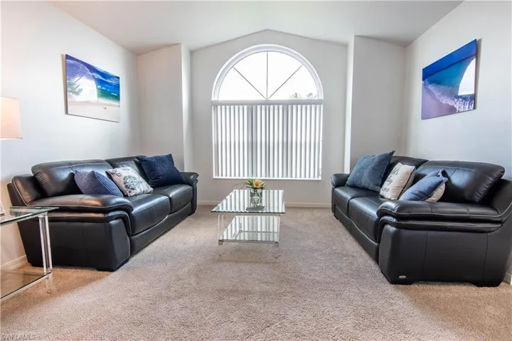 Living room with vaulted ceiling and carpet floors