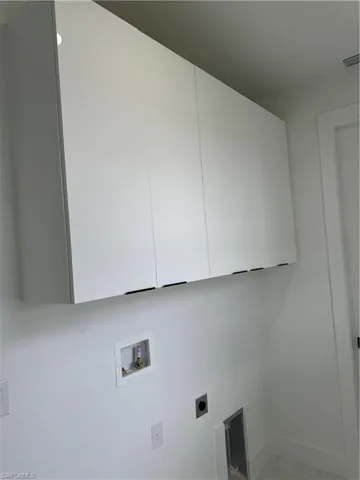 Laundry area featuring hookup for a washing machine, hookup for an electric dryer, and cabinets