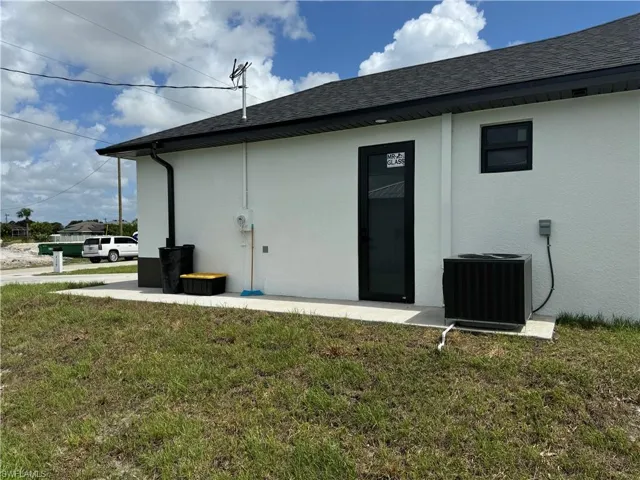 Back of property featuring a yard and central AC unit