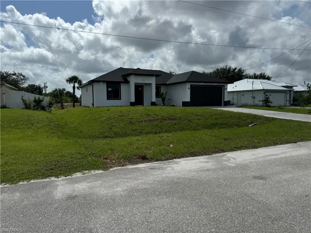 View of front of property with a garage and a front yard