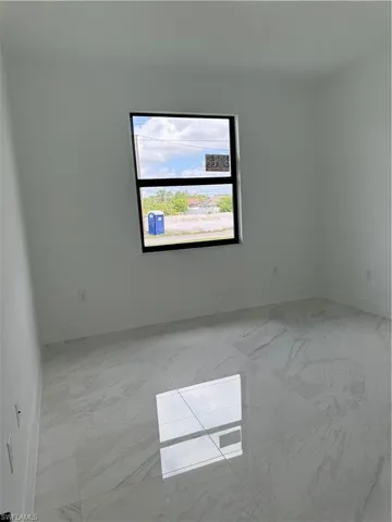 Empty room featuring light tile floors