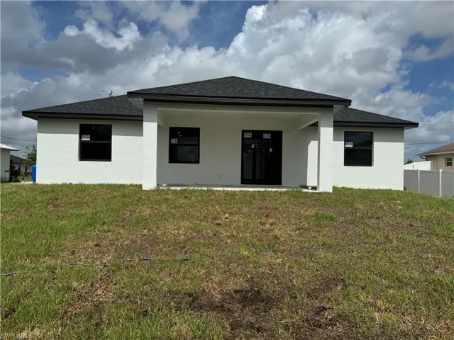 Rear view of house featuring a lawn