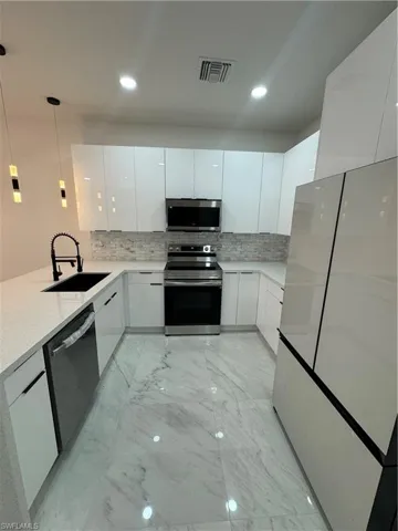 Kitchen with sink, tasteful backsplash, dishwashing machine, and stainless steel range with electric stovetop