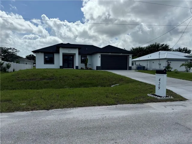 View of front facade with a front lawn and a garage