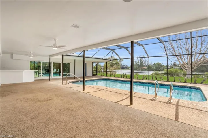 View of pool featuring a patio, ceiling fan, and a lanai