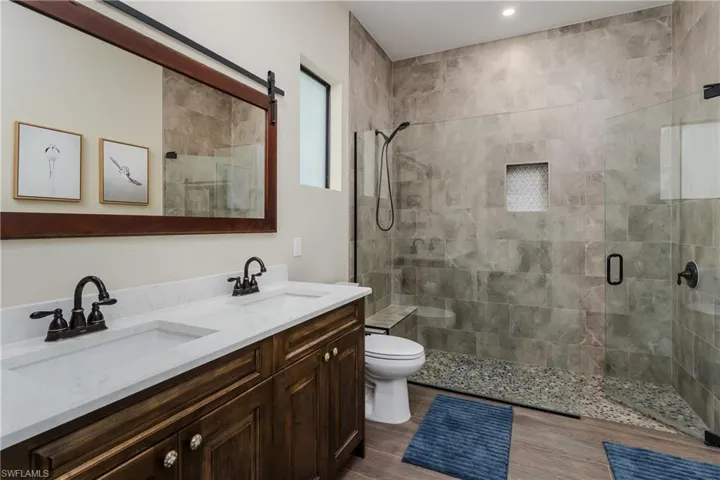 Bathroom featuring a dual vanity with wood-finish cabinetry and white countertops
