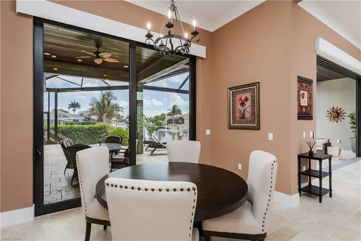 Indoor-outdoor living space featuring expansive sliding glass doors, a screened patio with a ceiling fan, and tiled flooring