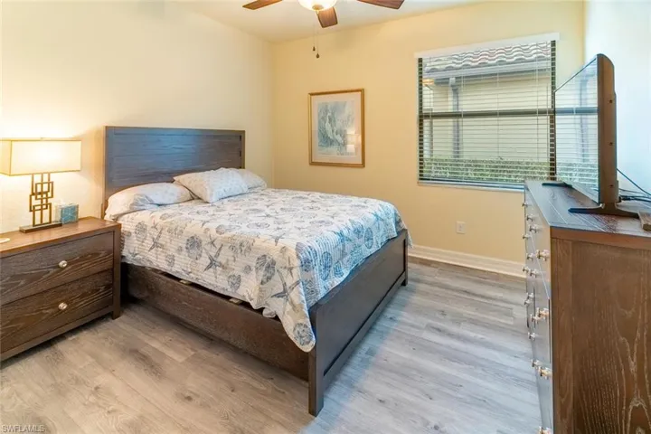 Bedroom with light wood-type flooring, a ceiling fan, and baseboards
