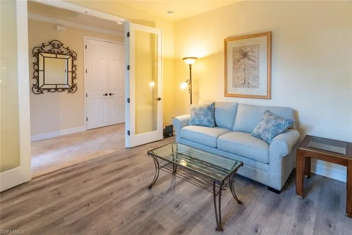 Living area featuring wood finished floors, baseboards, and french doors