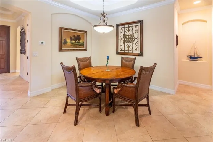 Dining room with baseboards, ornamental molding, and light tile patterned floors