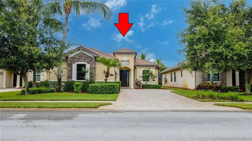 Mediterranean / spanish house featuring stone siding, a tiled roof, a front lawn, and stucco siding