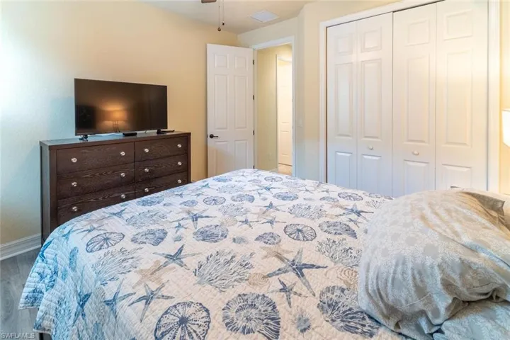 Bedroom with visible vents, baseboards, wood finished floors, and a closet