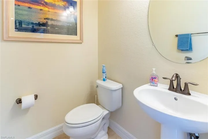 Bathroom featuring toilet, baseboards, and a sink