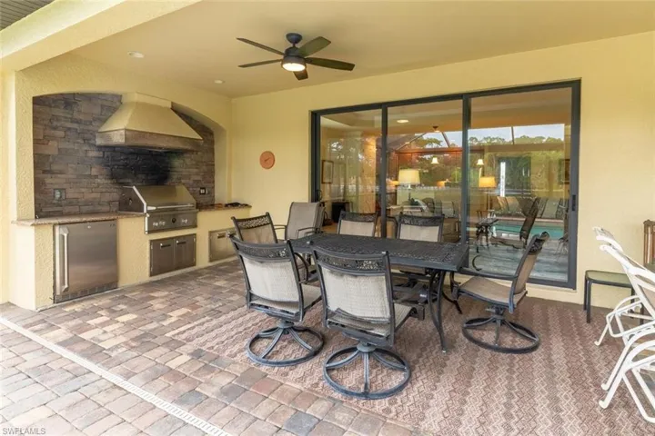 View of patio / terrace with area for grilling, ceiling fan, outdoor dining space, and exterior kitchen