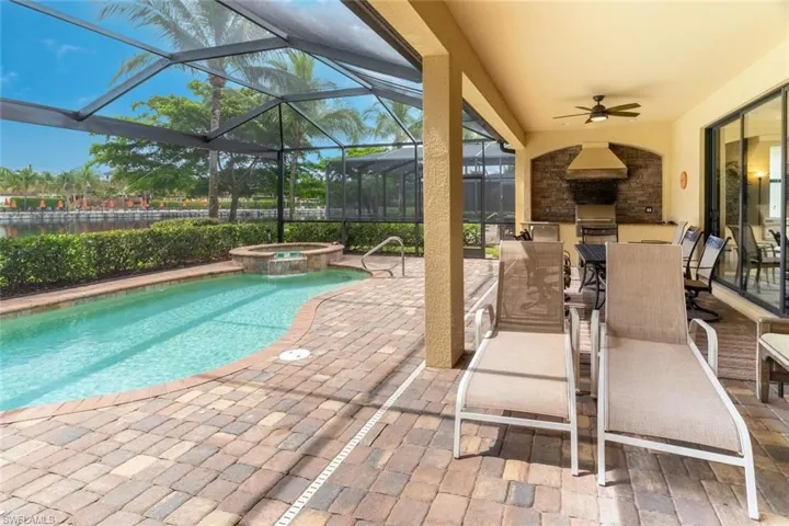 View of swimming pool with a ceiling fan, glass enclosure, area for grilling, and a patio