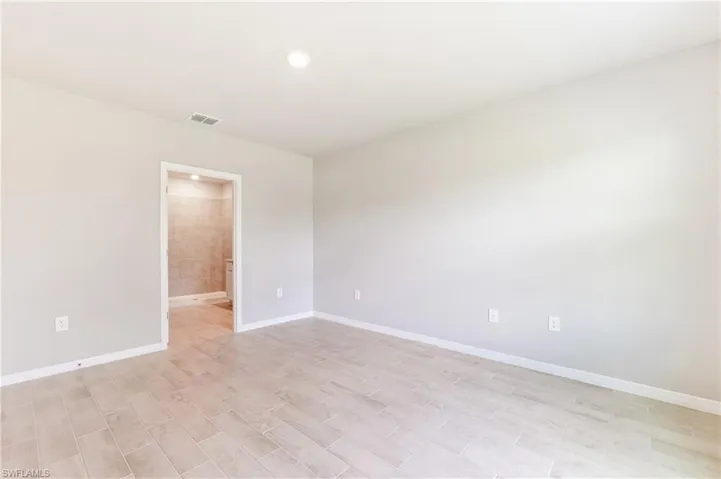 Empty room featuring baseboards and light wood-style flooring