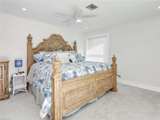 Carpeted bedroom featuring ceiling fan