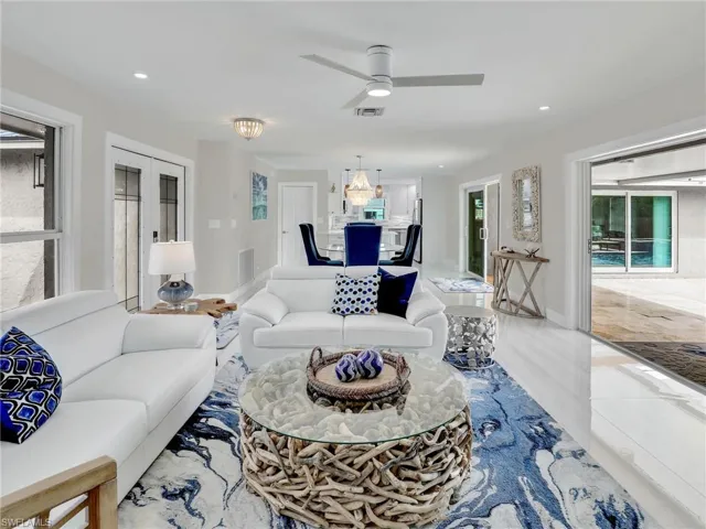 Living room featuring french doors, tile patterned floors, ceiling fan, and plenty of natural light
