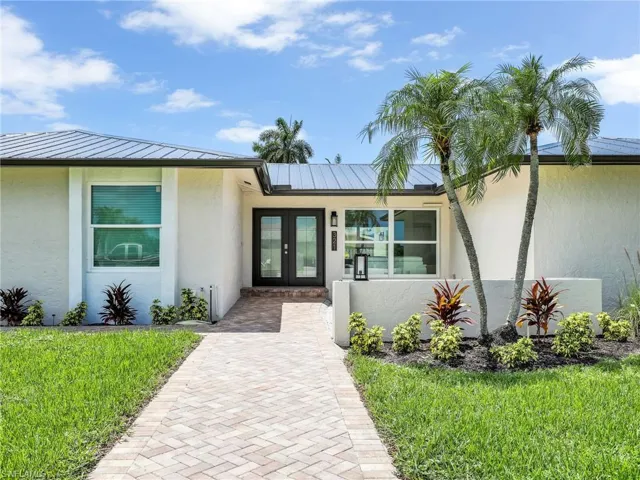 Property entrance featuring french doors and a lawn