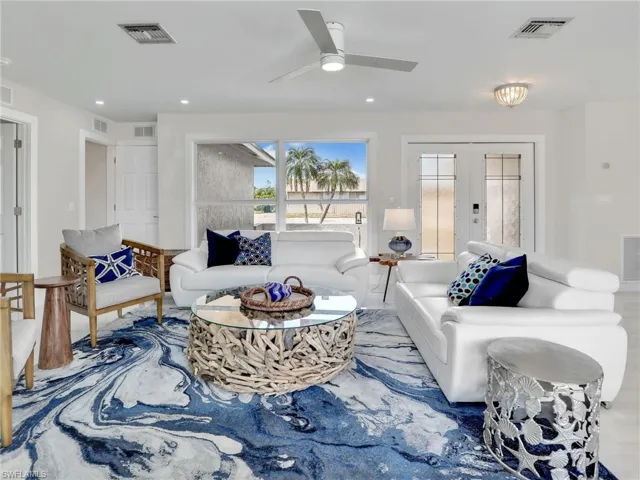 Living room featuring wood-type flooring, french doors, and ceiling fan
