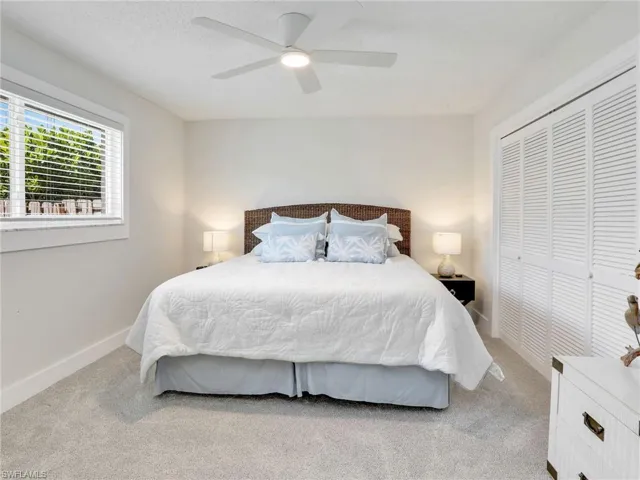 Carpeted bedroom with a closet and ceiling fan
