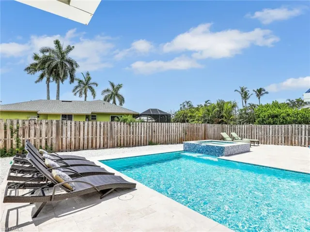 View of pool with an in ground hot tub and a patio