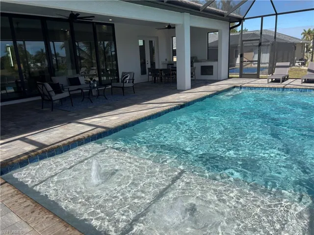 View of pool featuring a patio, ceiling fan, and a lanai