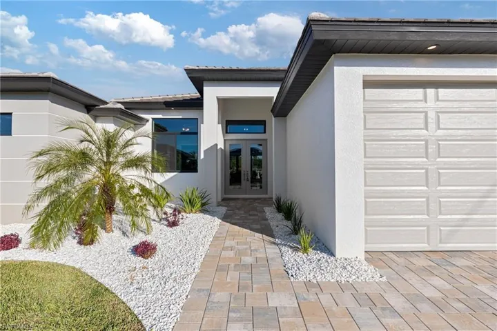 Doorway to property featuring a garage and french doors