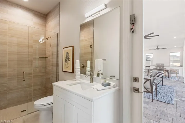Bathroom featuring vanity, toilet, and a shower with shower door