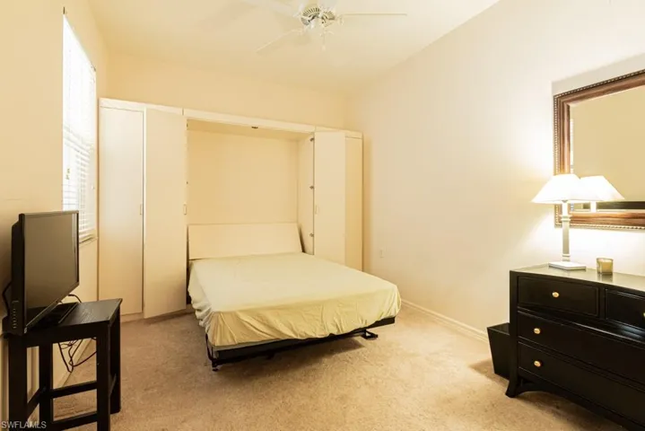 Bedroom with light colored carpet and ceiling fan