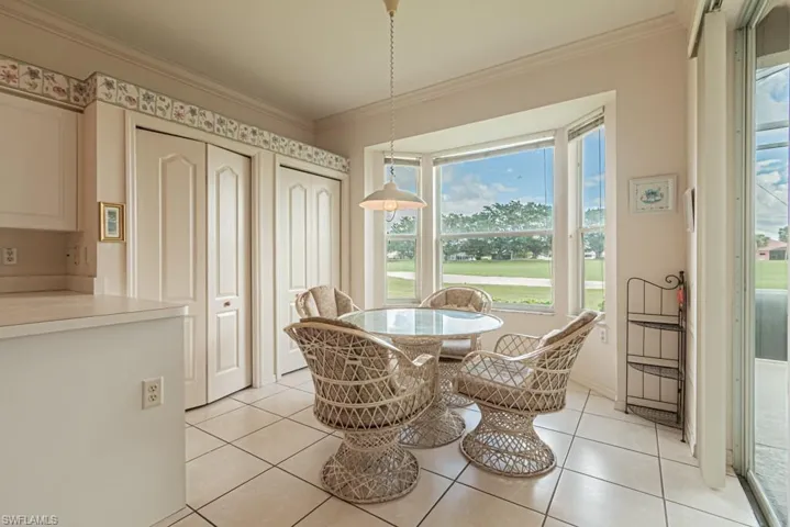 Dining area with light tile patterned floors and ornamental molding