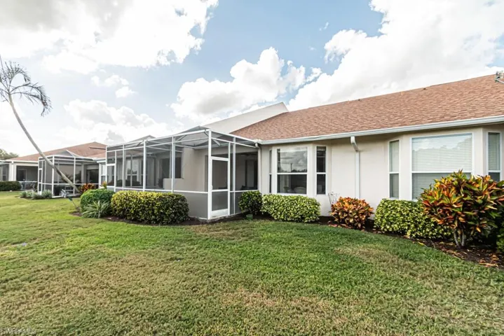 Rear view of property featuring a lanai and a yard