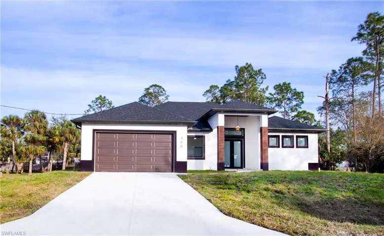 View of front of home with a garage and a front yard