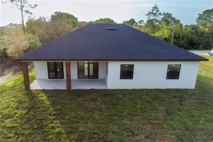 Back of property featuring a patio and a yard