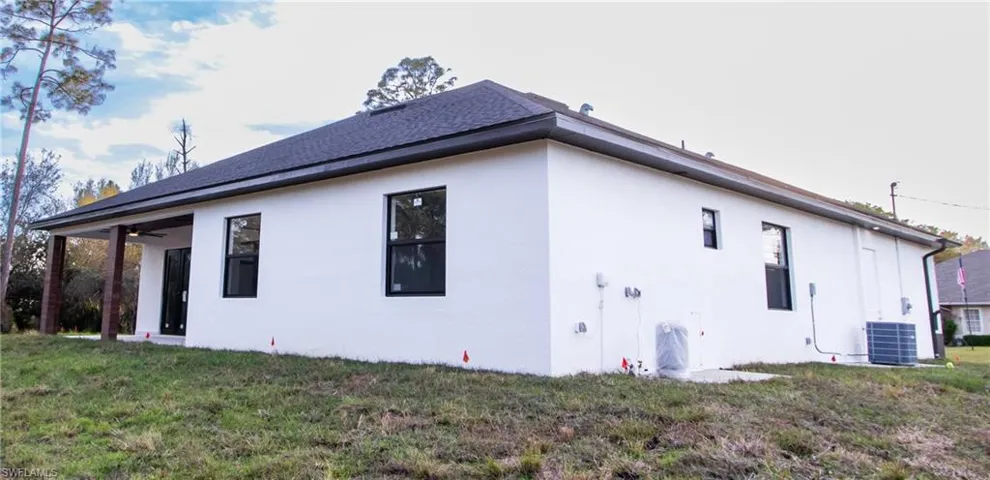 View of property exterior with central AC and a lawn