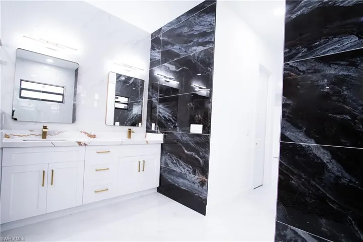 Bathroom featuring vanity and tile walls