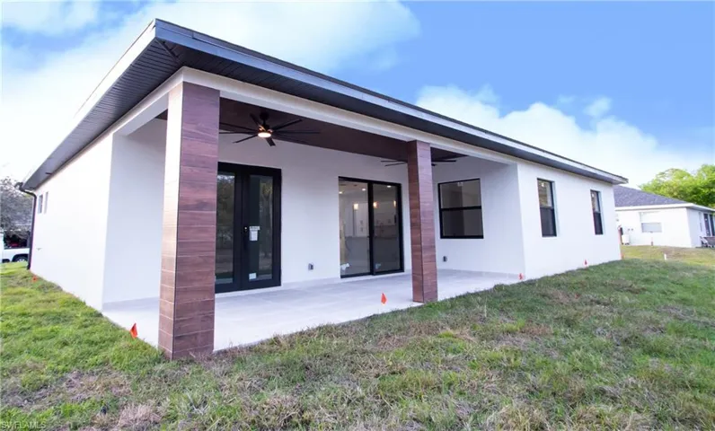 Back of house featuring a patio, a yard, and ceiling fan