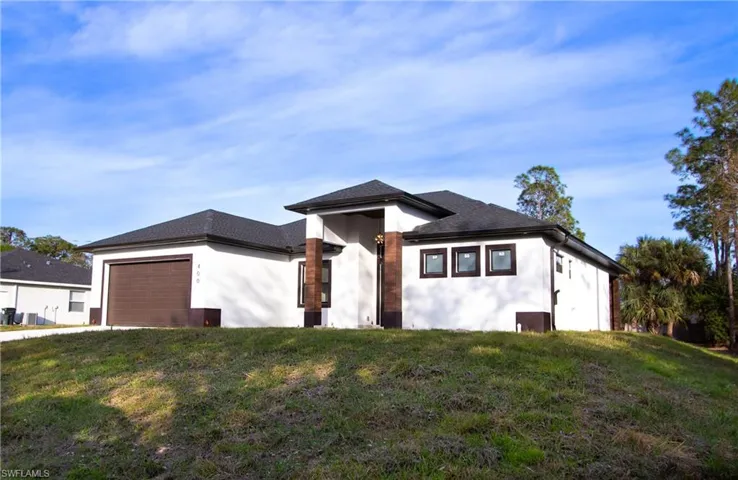 View of front of property with a garage and a front lawn