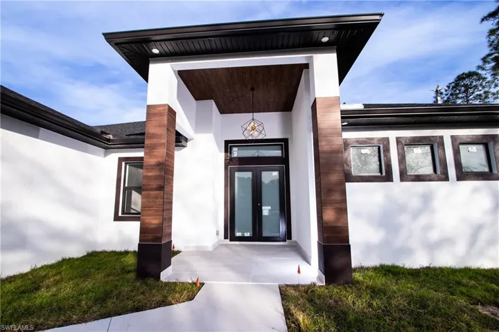 Property entrance with french doors and a lawn
