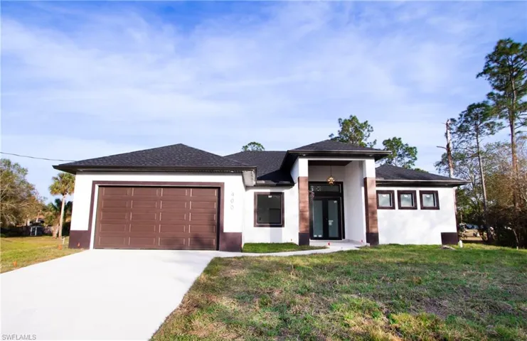 Prairie-style home with a garage and a front lawn