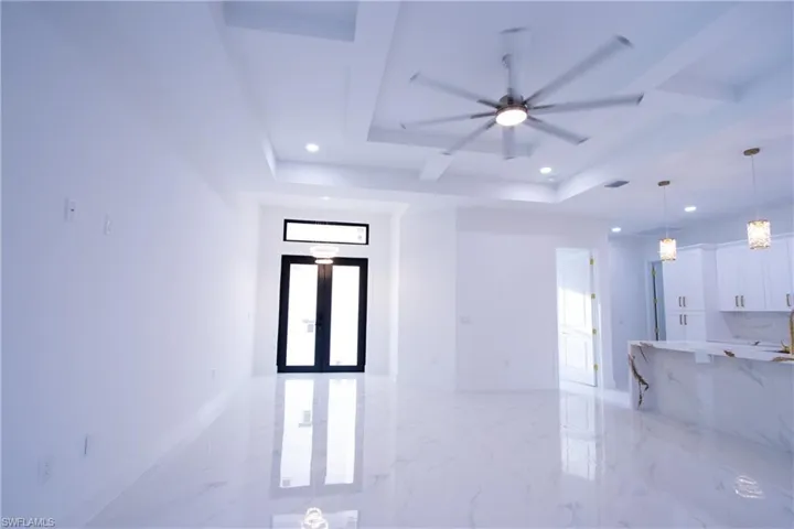 Spare room featuring a tray ceiling, french doors, and ceiling fan