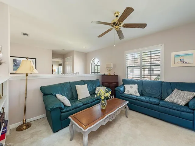 Living room featuring carpet flooring and a ceiling fan