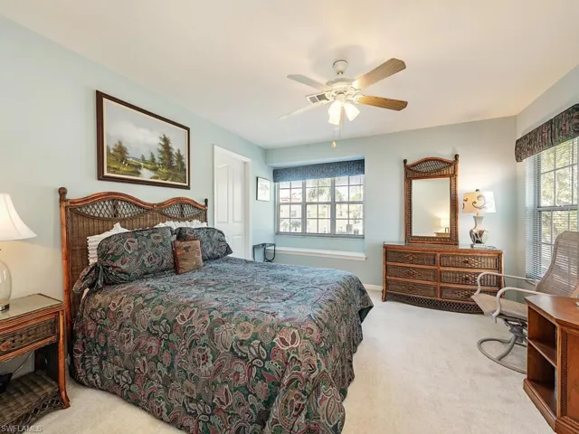 Bedroom with light colored carpet and a ceiling fan