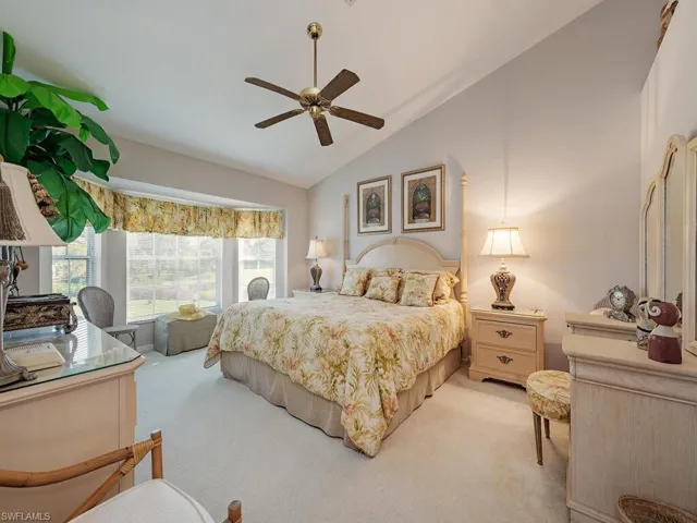 Bedroom featuring vaulted ceiling, carpet flooring, and a ceiling fan