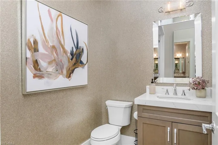 Half bath just off entryway/den is convenient and beautiful.